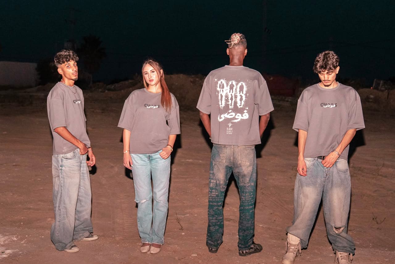 Four people wearing the Torenza Studio CHAOS tee at night